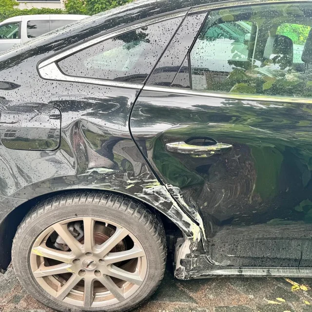Dokumentierter Seitenschaden an einem schwarzen Fahrzeug
